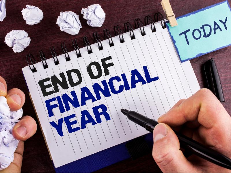 A man write the words 'End of Financial Year' on a notebook